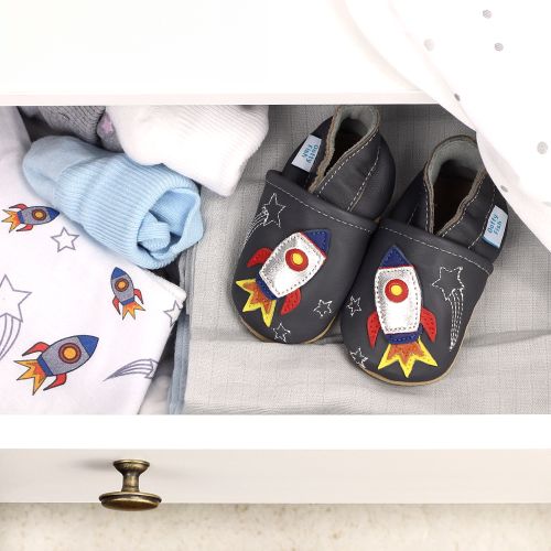 Babyschuhe mit Raketenmotiv, in Schublade mit Babykleidung.