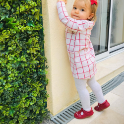 Kleines Mädchen trägt Dotty Fish rote Lederschuhe mit Gummisohle und T-Bar.