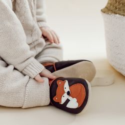 Kleinkind trägt braune Lauflernschuhe aus Leder von Dotty Fish mit orange-weißem Fuchsdesign.