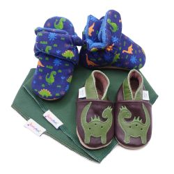 Dotty Fish Baby-Geschenkset mit Dinosaurierstiefeln aus Baumwolle, Krabbelschuhen aus Leder und zwei grünen Babylätzchen.