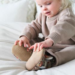 Kleinkind trägt Baumwollstiefeletten mit Waldmuster.