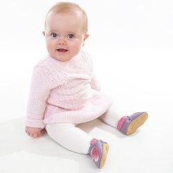 Baby Mädchen sitzt und trägt lila Dotty Fish Barfußschuhe mit rosa Knöchel trimmen und rosa Schmetterling Design.